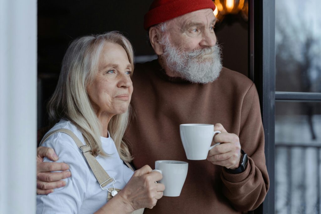 A senior couple embraces while enjoying coffee, symbolizing love and companionship.