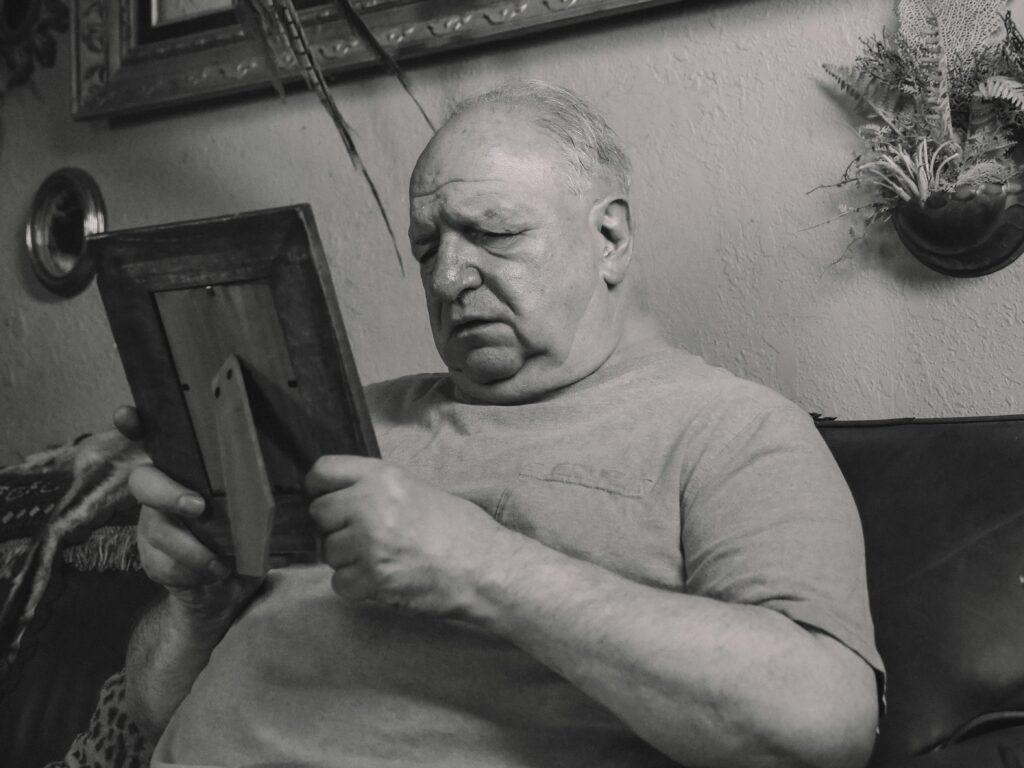 A senior man holding a wooden frame in one of the dementia care homes in Johannesburg